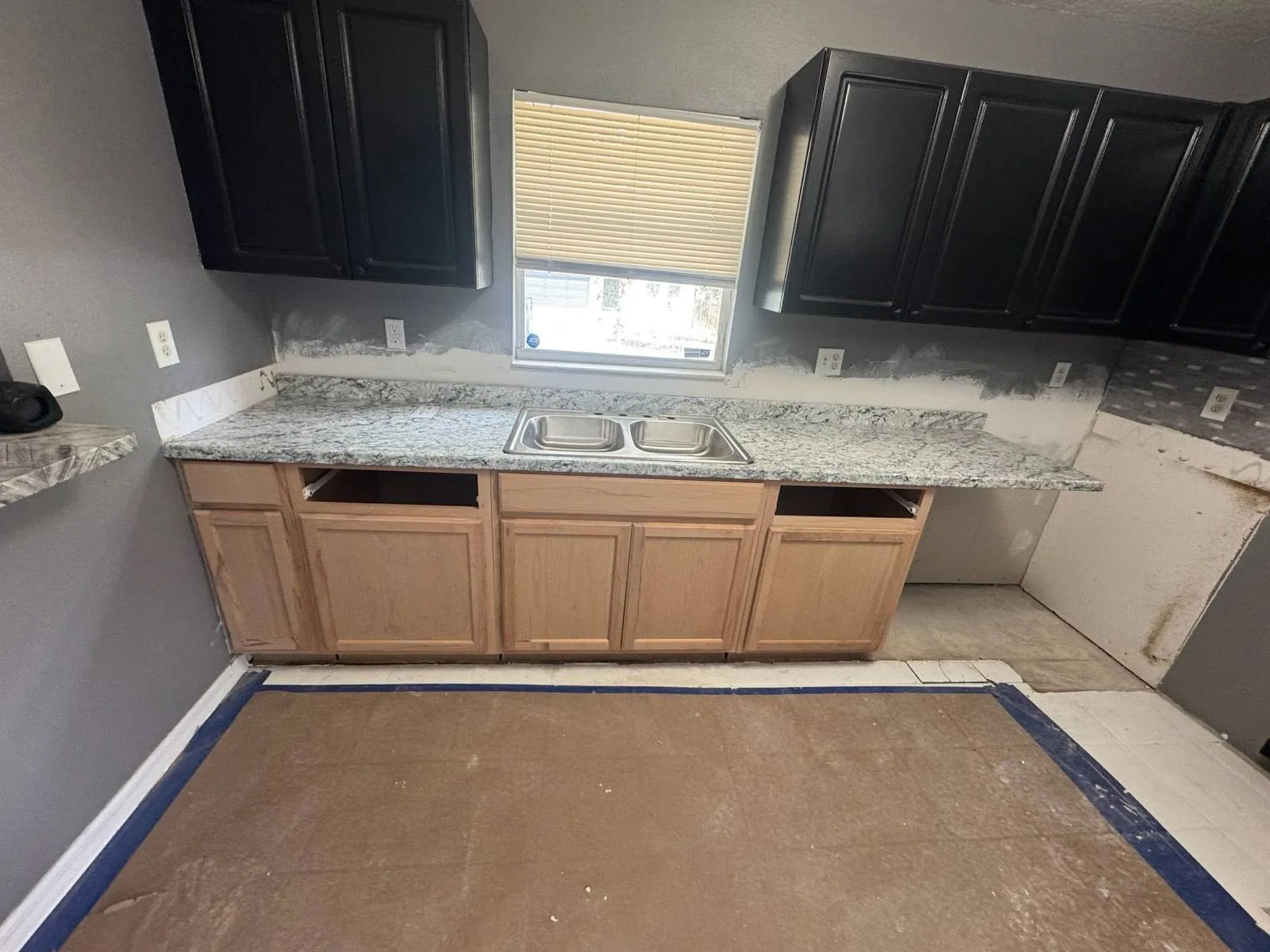 A Tampa kitchen mid-rehabilitation with new base cabinets installed and walls prepped, countertops not yet set