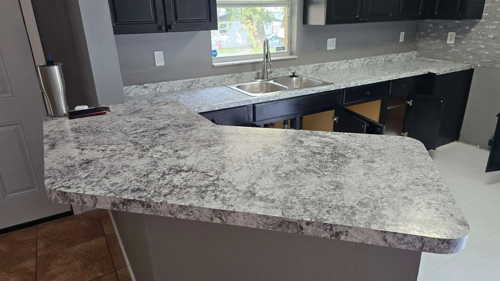 The finished granite breakfast bar and completed kitchen after the property rehabilitation